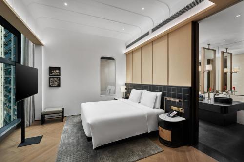 a hotel room with a white bed and a sink at HUALUXE Shenzhen Bao'an in Shenzhen
