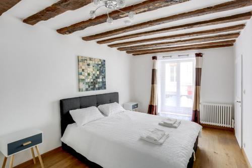 une chambre avec un grand lit blanc et une fenêtre dans l'établissement Bluestay 214 - Superb apartment in Paris, à Paris