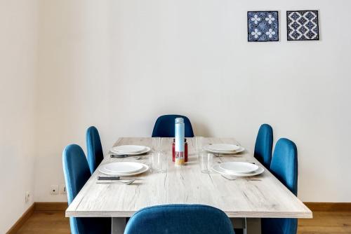 une table en bois entourée de chaises bleues dans l'établissement Bluestay 214 - Superb apartment in Paris, à Paris