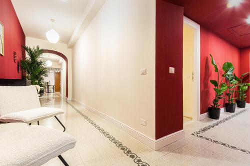 a hallway with red walls and chairs and plants at DomusFebo SanGiovanniSuites in Rome