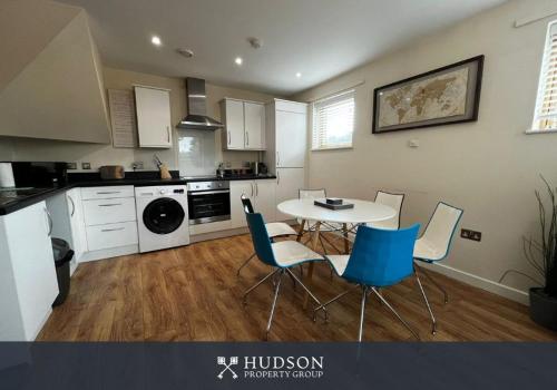 a kitchen with a table and chairs in a room at Three Bedroom Townhouse with Parking in Telford