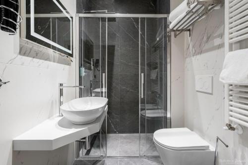 a bathroom with a toilet and a sink and a shower at Hotel Adamas in Florence