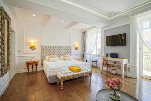 a white bedroom with a bed and a desk at Casa Kallergi in Chania Town