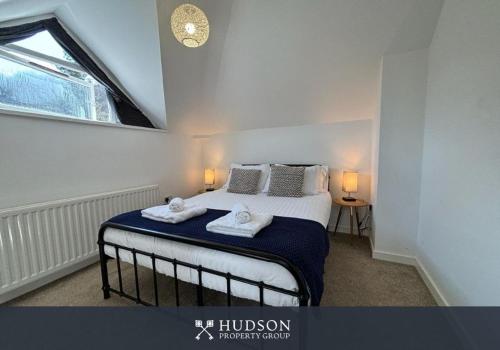 a bedroom with a bed with two towels on it at Ironbridge Home with Roof Terrace in Ironbridge