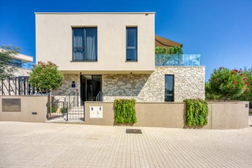 a large white house with bushes in front of it at Villa 19 in Savudrija