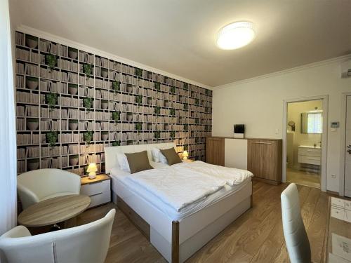 a bedroom with a bed and a table and a chair at Camille Apartmanhouse in Budapest