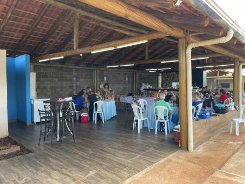 un groupe de personnes assises à des tables dans un restaurant dans l'établissement Chacara a Grande Familia, Bairro Andorinhas Otima Nova, à Uberlândia