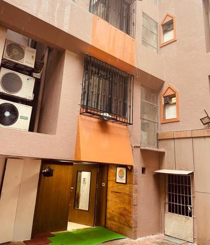 a building with a wooden door and a balcony at TIM Service Apartment Goregaon East Near NESCO in Mumbai