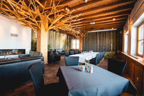 a restaurant with tables and chairs and a fireplace at Fichtelberghaus in Kurort Oberwiesenthal