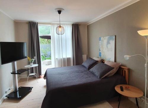 a bedroom with a bed and a large window at Well Design apartment in Rønne in Rønne