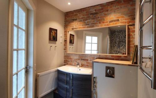 a bathroom with a sink and a brick wall at Well Design apartment in Rønne in Rønne