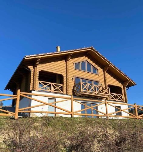 a large wooden house on top of a hill at Monte Vista 2 in Rostoka