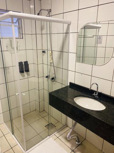 a bathroom with a glass shower and a sink at Real NOB Hotel in Orleans