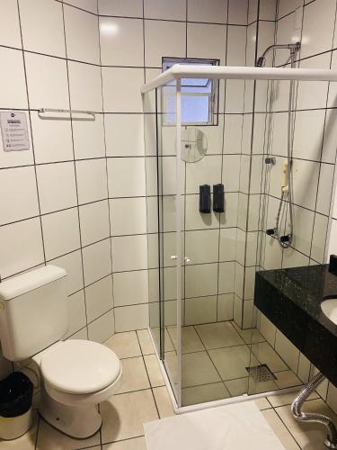 a bathroom with a toilet and a glass shower at Real NOB Hotel in Orleans