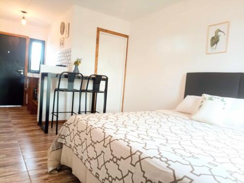 a bedroom with a bed and a table and a window at Laguna Studios in El Calafate