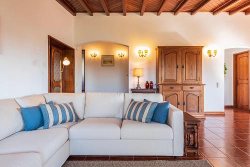 a living room with a white couch and blue pillows at Atlantic Villa - Mindelo Beach in Vila Chã