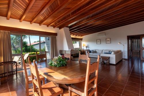 a dining room and living room with a wooden table at Atlantic Villa - Mindelo Beach in Vila Chã