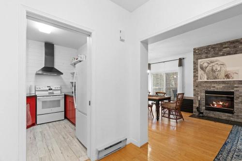 a kitchen and dining room with a fireplace at Le Champetre Tremblant 2bdrs Condo W Fireplace in Mont-Tremblant