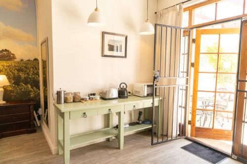 a kitchen with a table with a microwave on it at Mitre's Edge Simonsberg Studio in Klapmuts