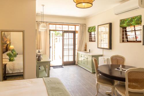 a kitchen and dining room with a table and a dining room at Mitre's Edge Simonsberg Studio in Klapmuts