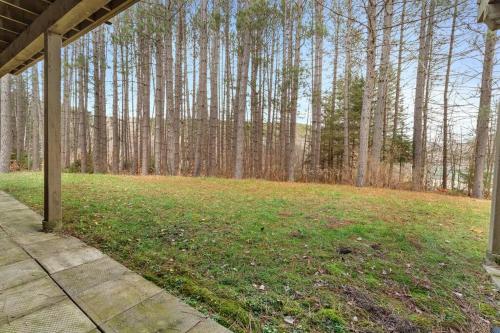 an empty yard with trees in the background at Le Champetre Tremblant 2bdrs Condo W Fireplace in Mont-Tremblant