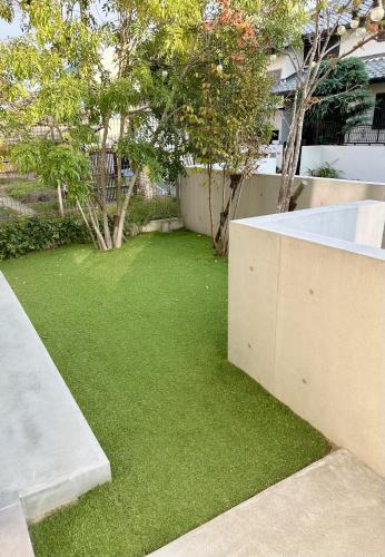 a yard with green grass next to a building at Accessible Four-Bedroom House near Kuzuha Station! in Hirakata