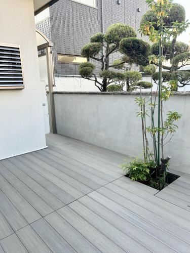 a courtyard with trees on a building at Accessible Four-Bedroom House near Kuzuha Station! in Hirakata