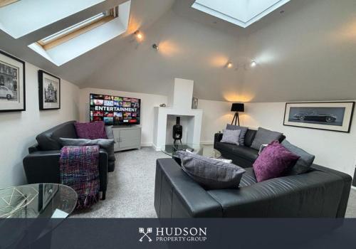 a living room with two couches and a tv at Ironbridge Townhouse with Roof Terrace and Parking in Ironbridge
