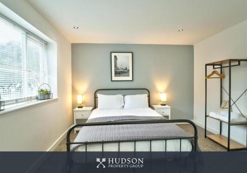 a bedroom with a bed with two lamps and a window at Ironbridge Townhouse with Roof Terrace and Parking in Ironbridge