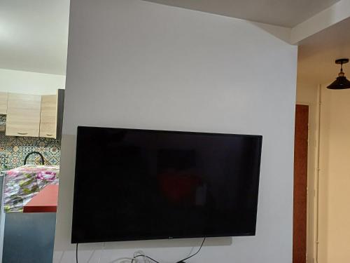Elle comprend une télévision à écran plat suspendue sur un mur blanc. dans l'établissement Studio, à Combs-la-Ville