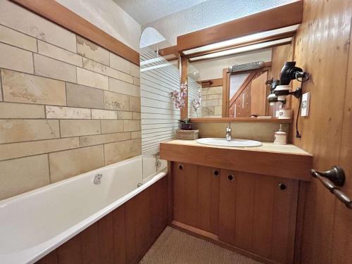 une salle de bain avec un lavabo et une baignoire dans l'établissement Appartement cosy à Megève: 3 pièces + mezzanine, 4 couchages - Proche remontées mécaniques et golf - FR-1-597-19, à Megève