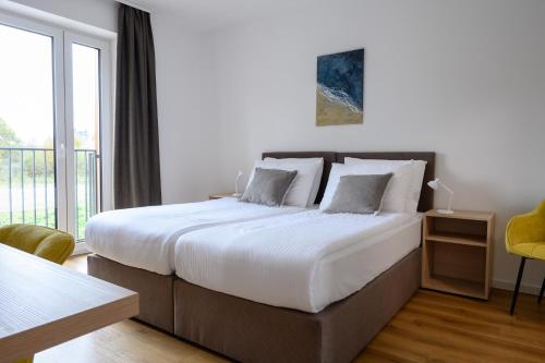 a bedroom with a large bed and a balcony at Hiša Janko in Dolenjske Toplice