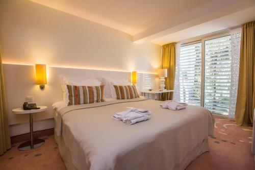 a hotel room with two towels on a bed at Amadria Park Ivan in Šibenik