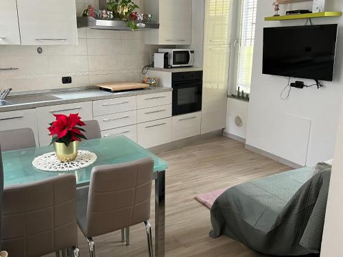 a kitchen with a small table with a red flower on it at Casa Emma in Porto Ceresio