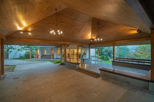 an open lobby of a house with wooden ceilings at Sterling Wayanad in Sultan Bathery