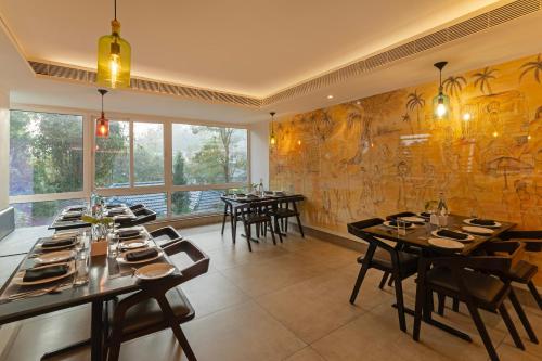 a restaurant with tables and chairs in a room at Sterling Wayanad in Sultan Bathery