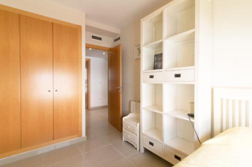 a bedroom with white shelves and a bed at Global Properties, Moderno y practico adosado en Puerto de Sagunto in Puerto de Sagunto