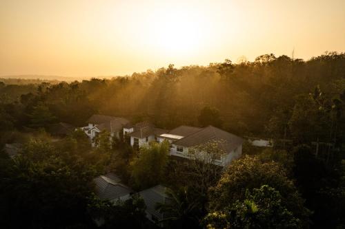 an aerial view of a house with the sun setting at Sterling Wayanad in Sultan Bathery