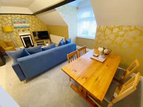 a living room with a blue couch and a table at The Beach Hut Walk to Beach Sleeps 4 Parking Pet Friendly in Bournemouth