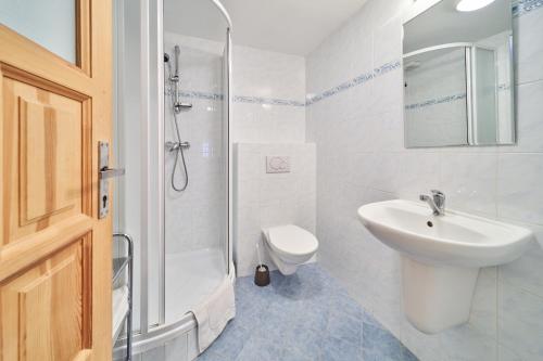 a white bathroom with a sink and a shower at Koula Apartments in Pec pod Sněžkou