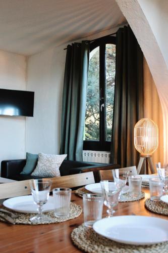 une table de salle à manger avec des assiettes et des verres dessus dans l'établissement Villa les Grillons, à Hyères