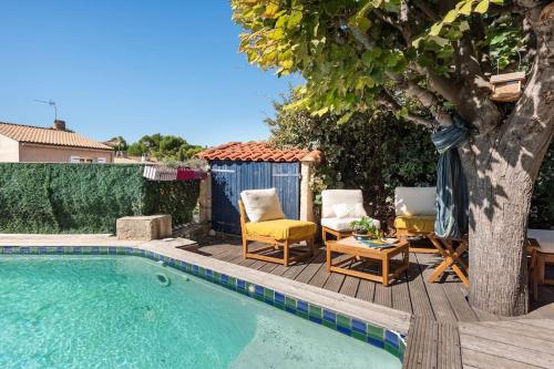 - une piscine avec 2 chaises et une table à côté d'un arbre dans l'établissement Maison Moderne avec Piscine, à Marseille