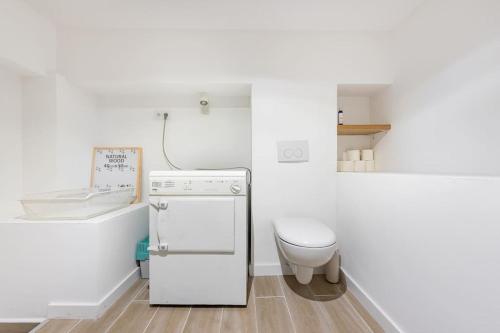 Il comprend une petite cuisine blanche avec des toilettes et un réfrigérateur. dans l'établissement Maison Moderne avec Piscine, à Marseille