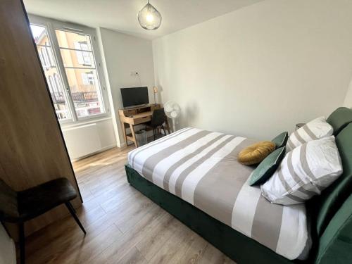 une chambre avec un lit et un bureau dans l'établissement Appartement idéalement situé, à Clermont-Ferrand
