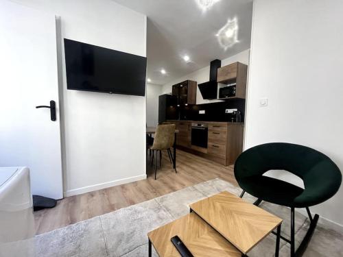 - un salon avec une chaise noire et une table dans l'établissement Appartement idéalement situé, à Clermont-Ferrand