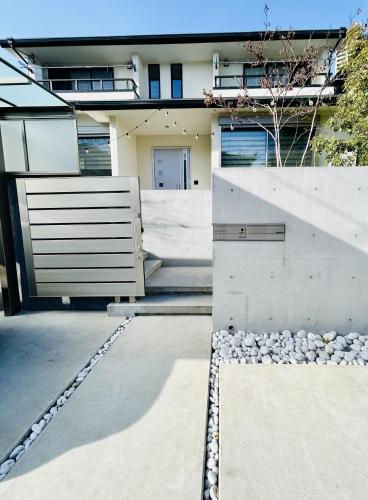 a house with a fence and a gate and rocks at Accessible Four-Bedroom House near Kuzuha Station! in Hirakata