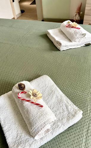 two towels with flowers on them on a bed at Casa Emma in Porto Ceresio