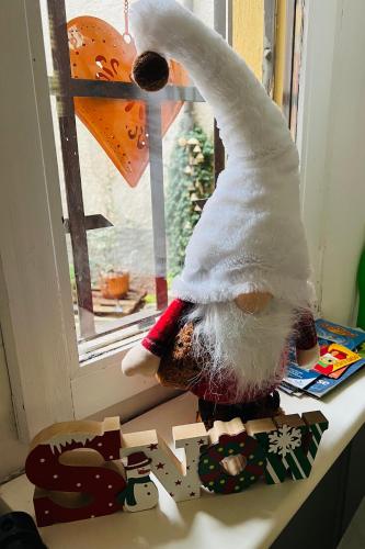 a stuffed teddy bear is standing on a window sill at Casa Emma in Porto Ceresio