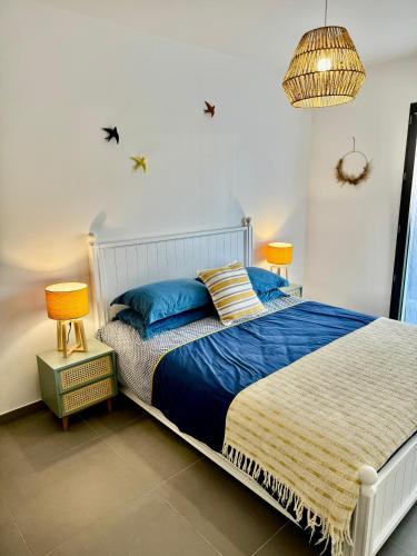 une chambre avec un lit avec une couette bleue dans l'établissement DOMAINE D'ARCA, T2 JARDIN PRIVE/PISCINE/TENNIS, à Porto-Vecchio