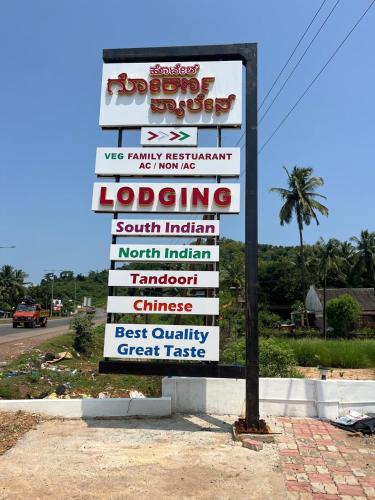 a sign for a restaurant on the side of a road at Hotel Gokarna Palace in Mādangeri